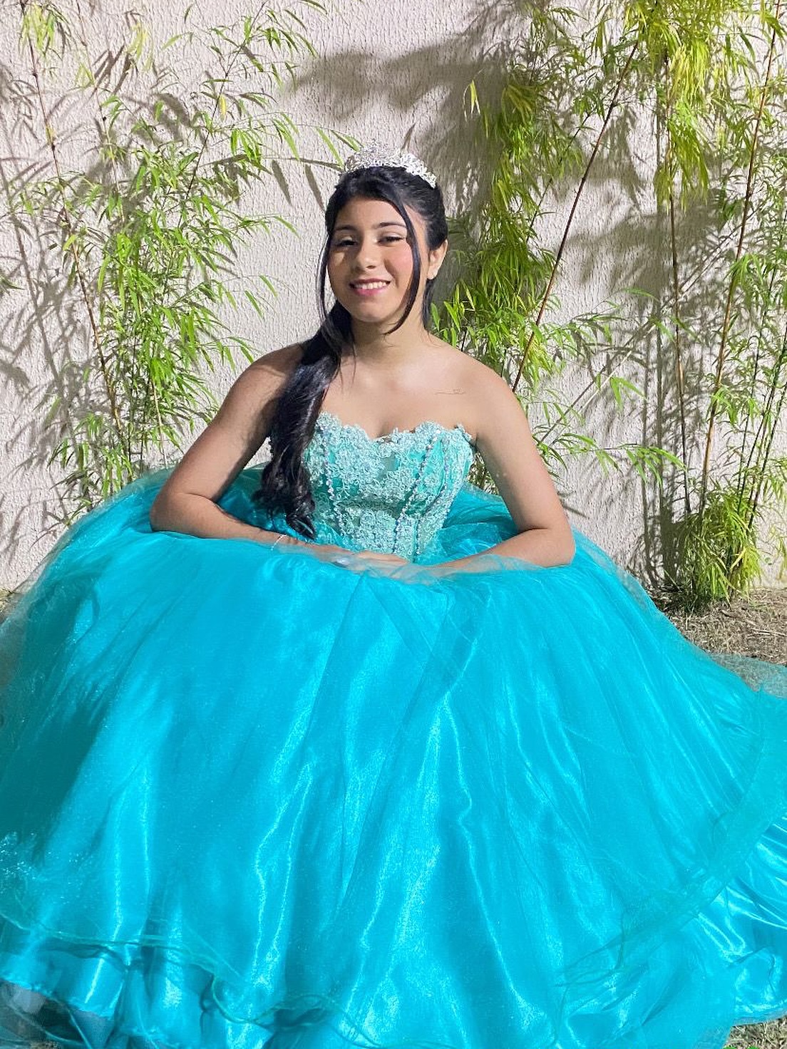Debutante sentada com vestido azul-turquesa volumoso